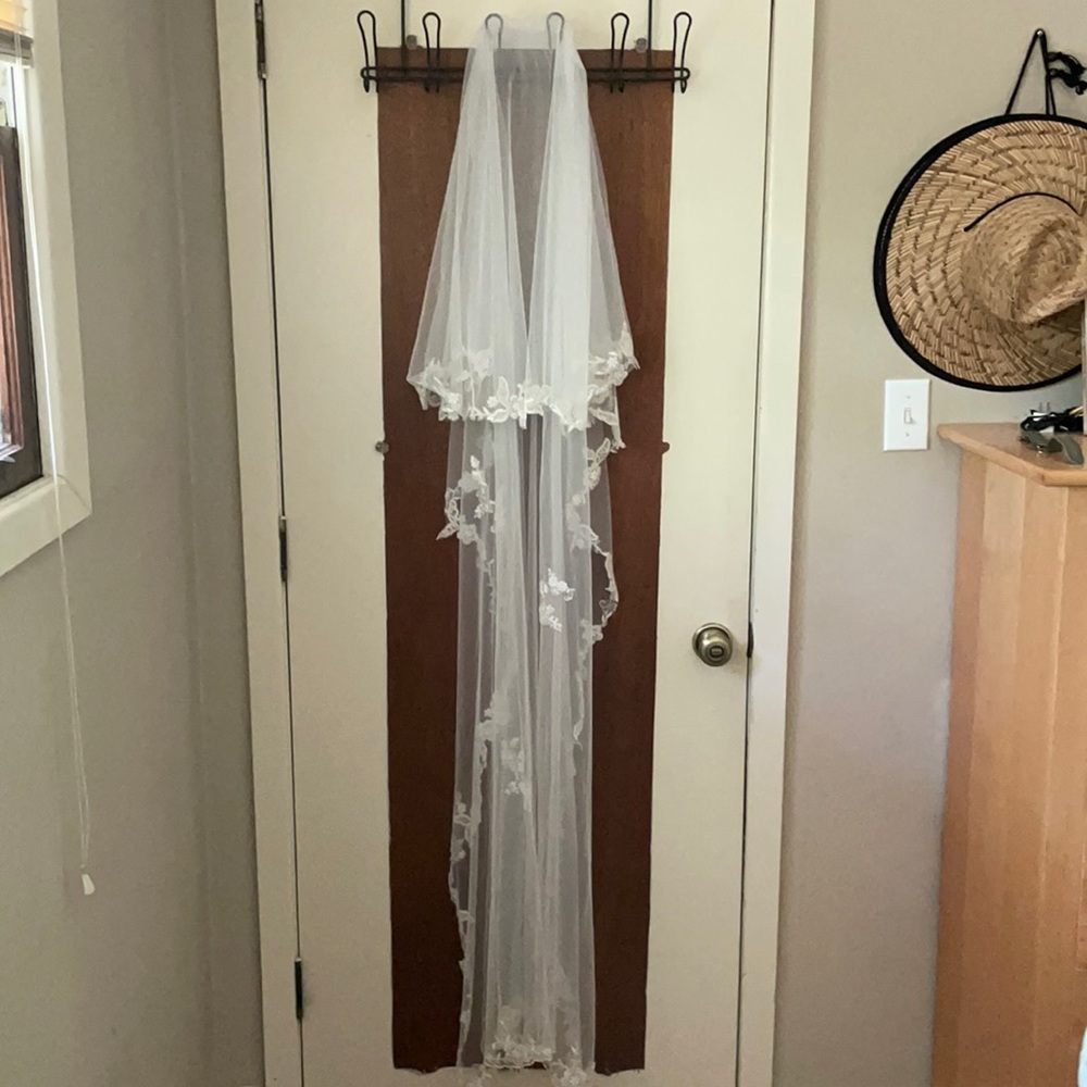 Chapel length white wedding veil with blusher.